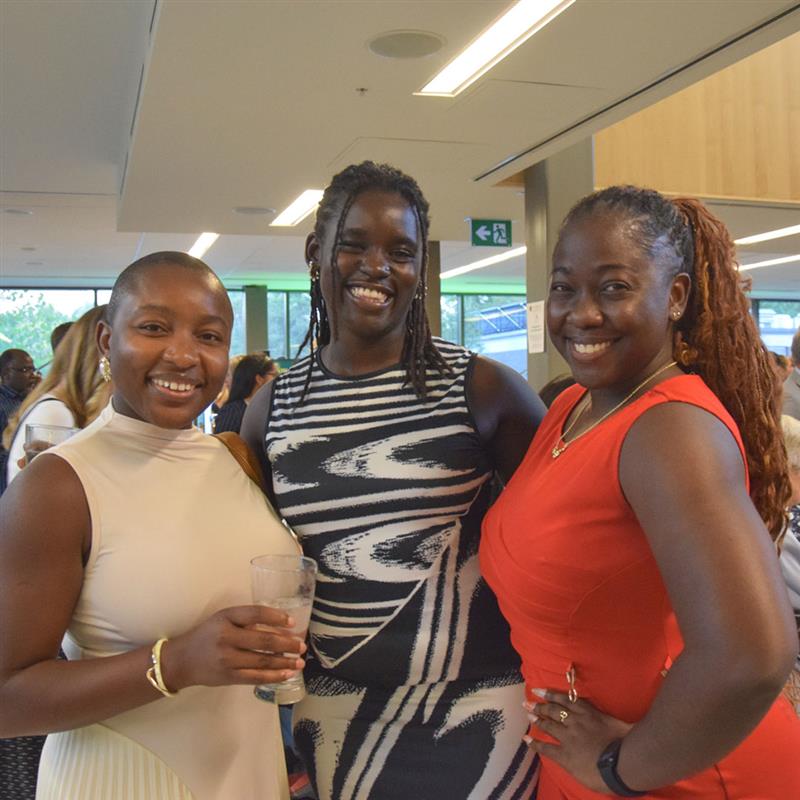three female students in nice dress smiling at the camera