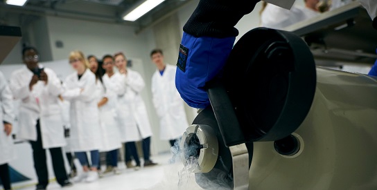 students gathered around to watch a physics experiment