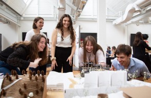 Students gathered around an architectural model to study it