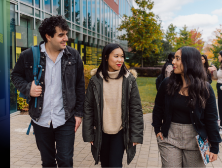 Three students walking in front of the Tatham Center