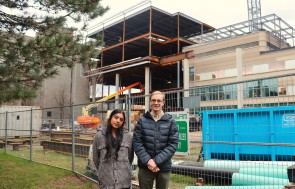 Two students standing in front of the construction for the new Math 4 building