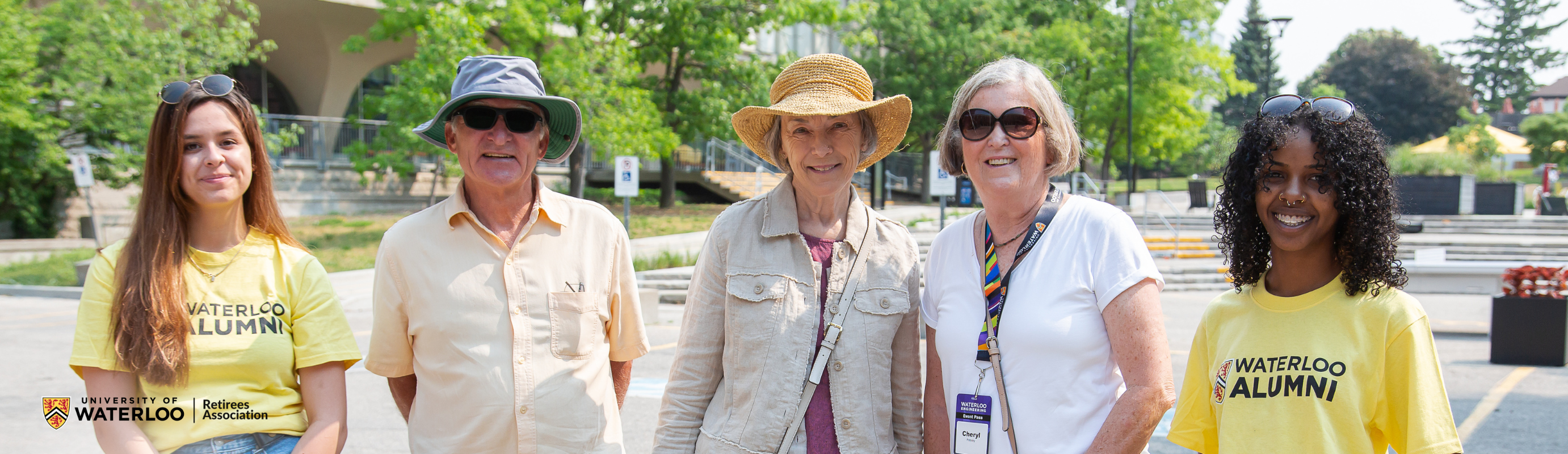 Two current students standing with three retirees in front of Dana Porter Library